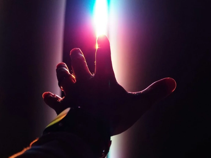 person holding lighted candle in dark room